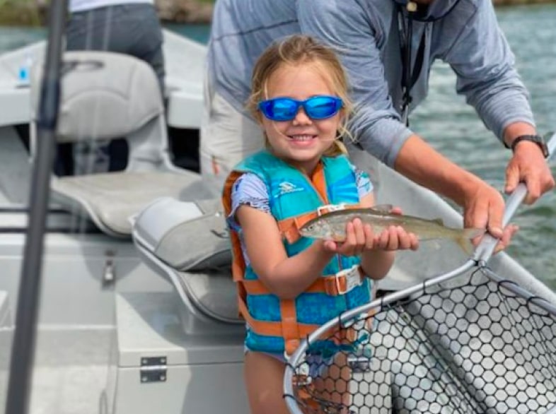 young girl holding little fish in jackson hole