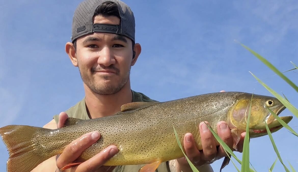 fly fishing guide holding fish