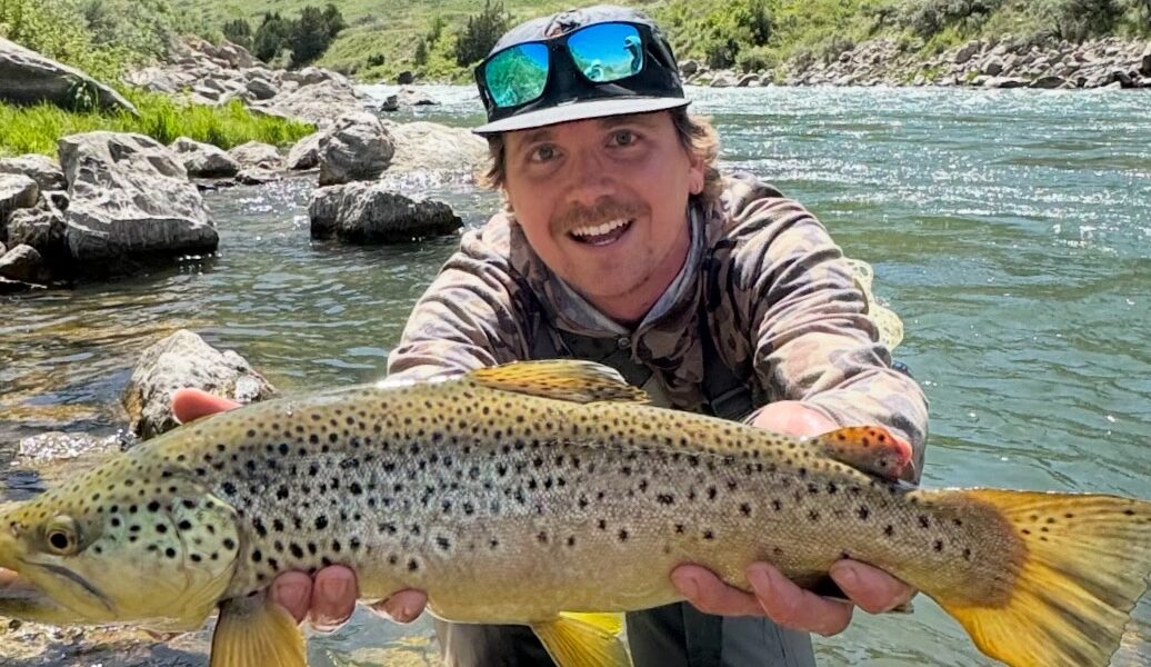 fly fishing guide holding fish