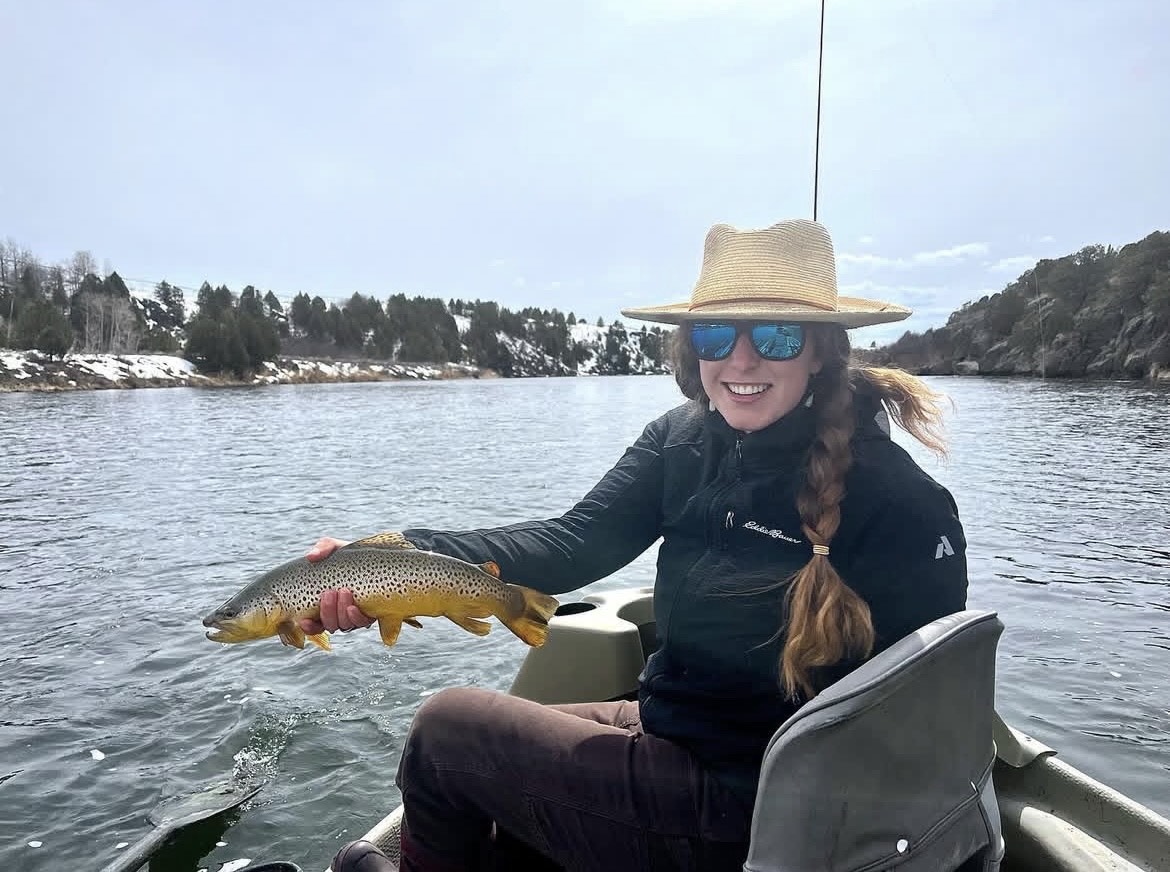 Kirstin Wade holding a brown trout on a drift boat